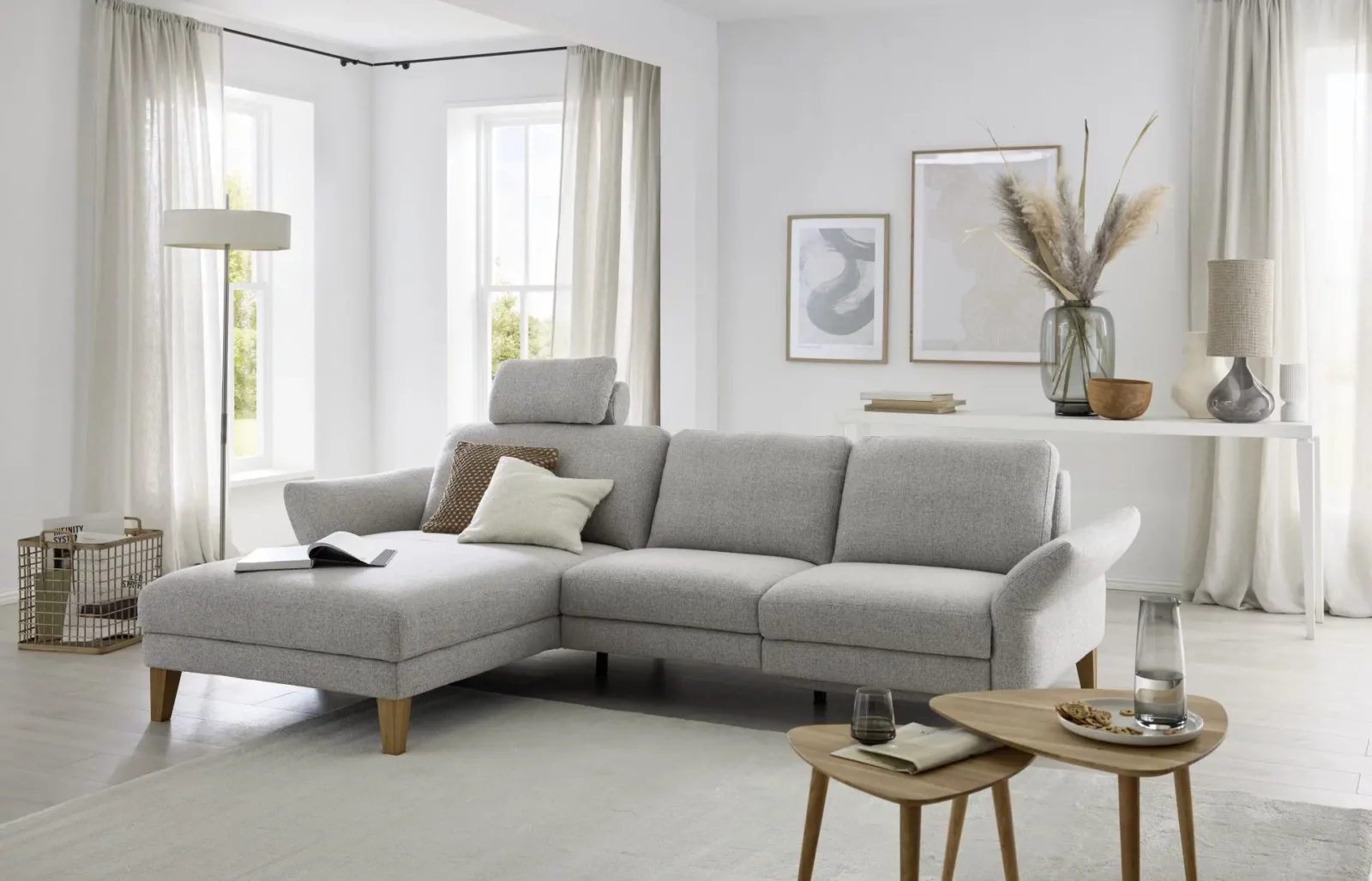 Sofa Giovanna in hellgrauem Stoff mit Holzfüßen und verstellbarer Kopfstütze.