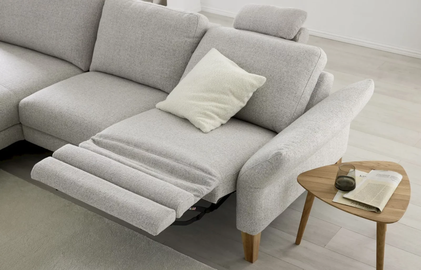 Sofa Giovanna in hellgrauem Stoff mit ausziehbarer Fußstütze.