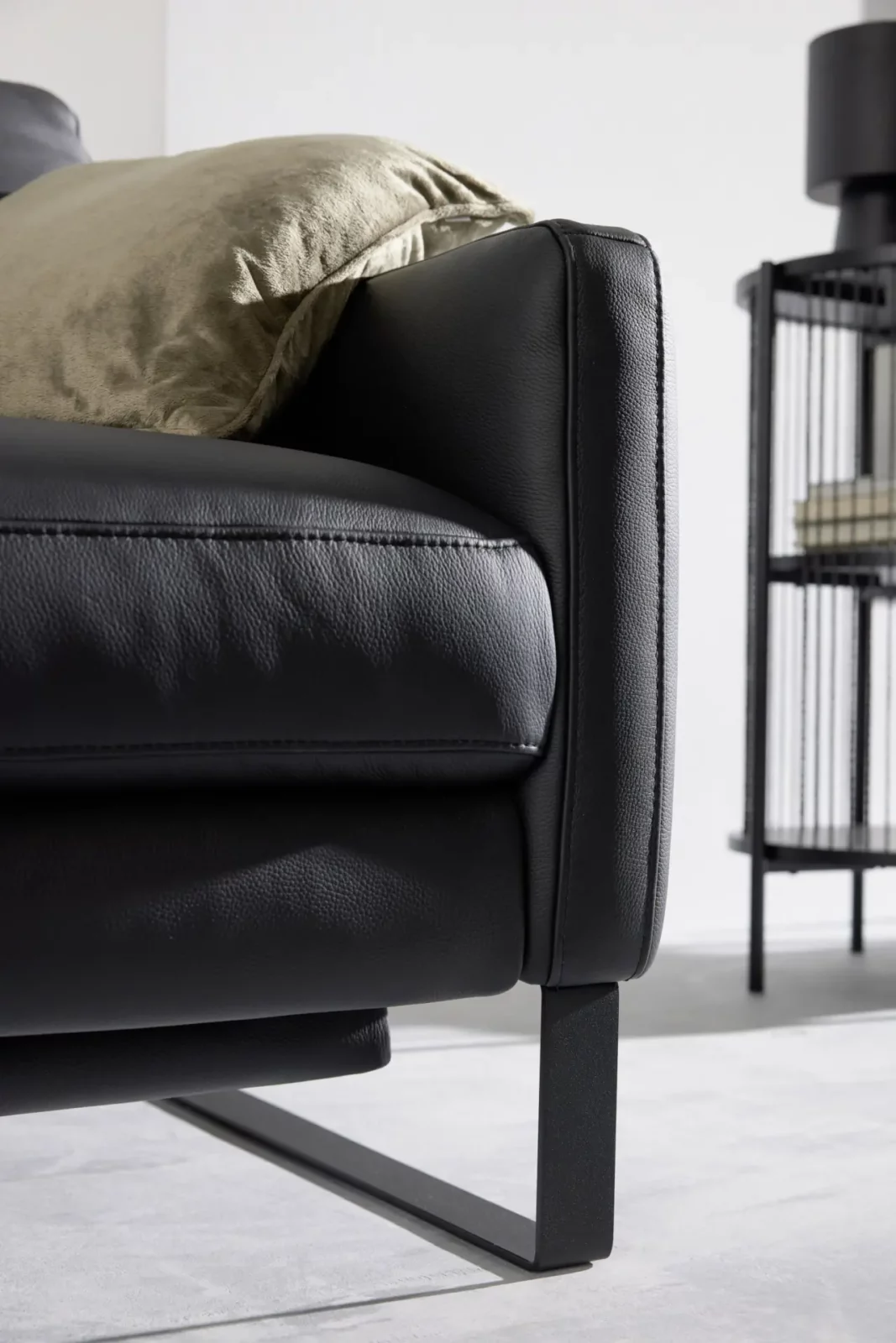 Sofa Giovanna in schwarzem Leder mit Metallbeinen und beigem Kissen.