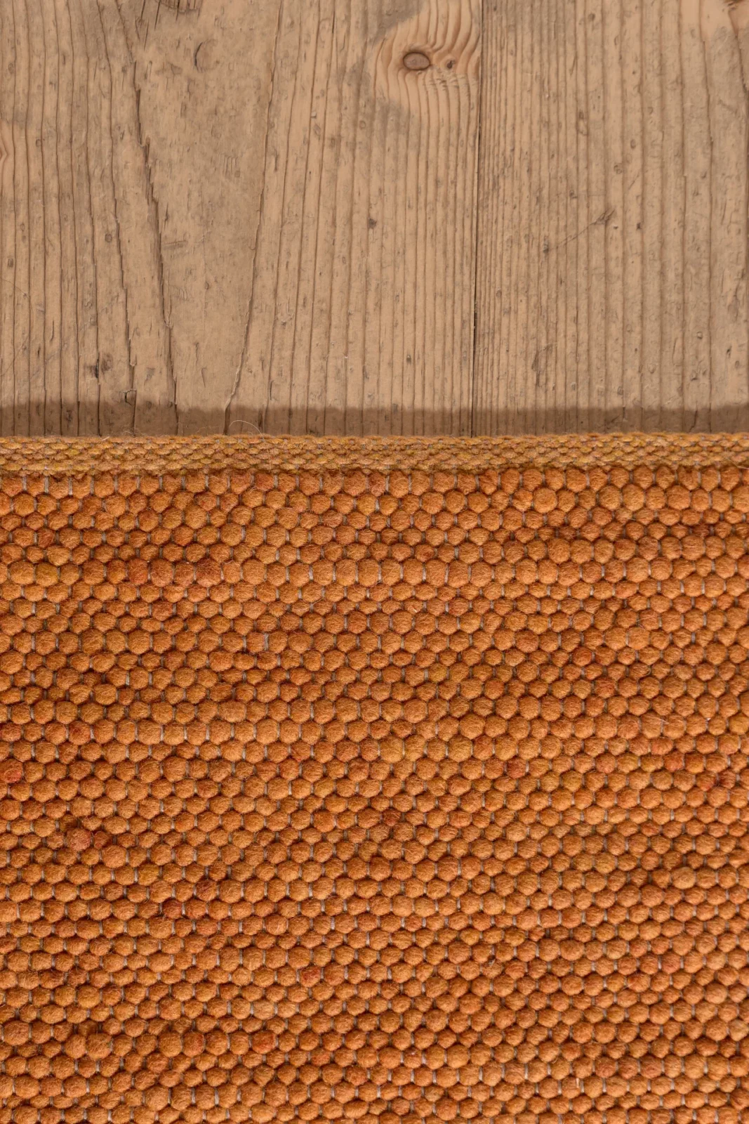 Teppich Tisca Olbia Florida 6310 in warmem Orange auf Holzboden.