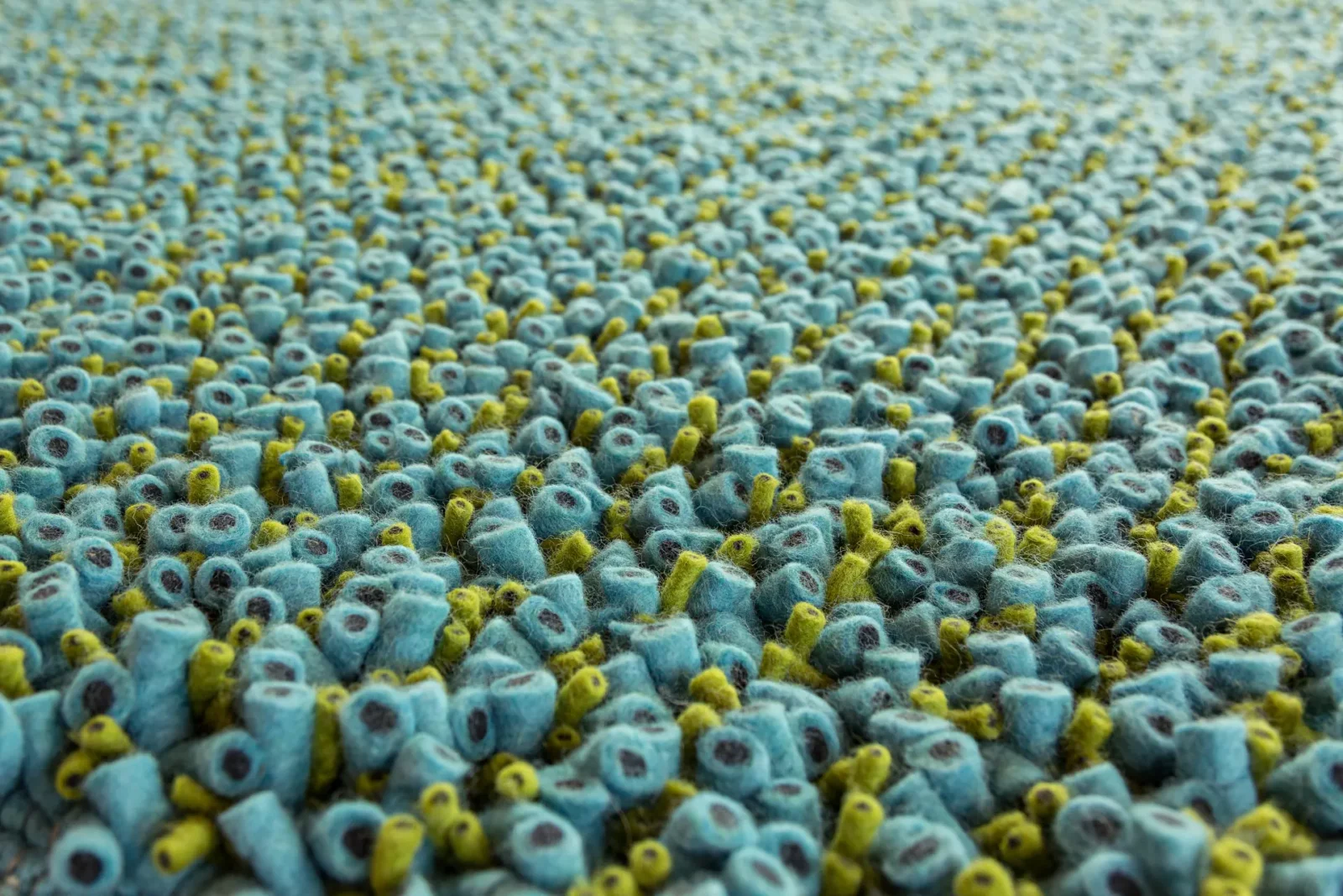 Teppich Tisca Olbia in Blau-Grün mit strukturierter Oberfläche.