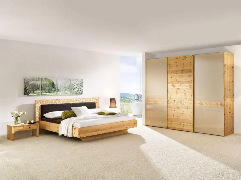 Zirbenbett und Kleiderschrank aus naturbelassenem Zirbenholz mit schlichten Linien.