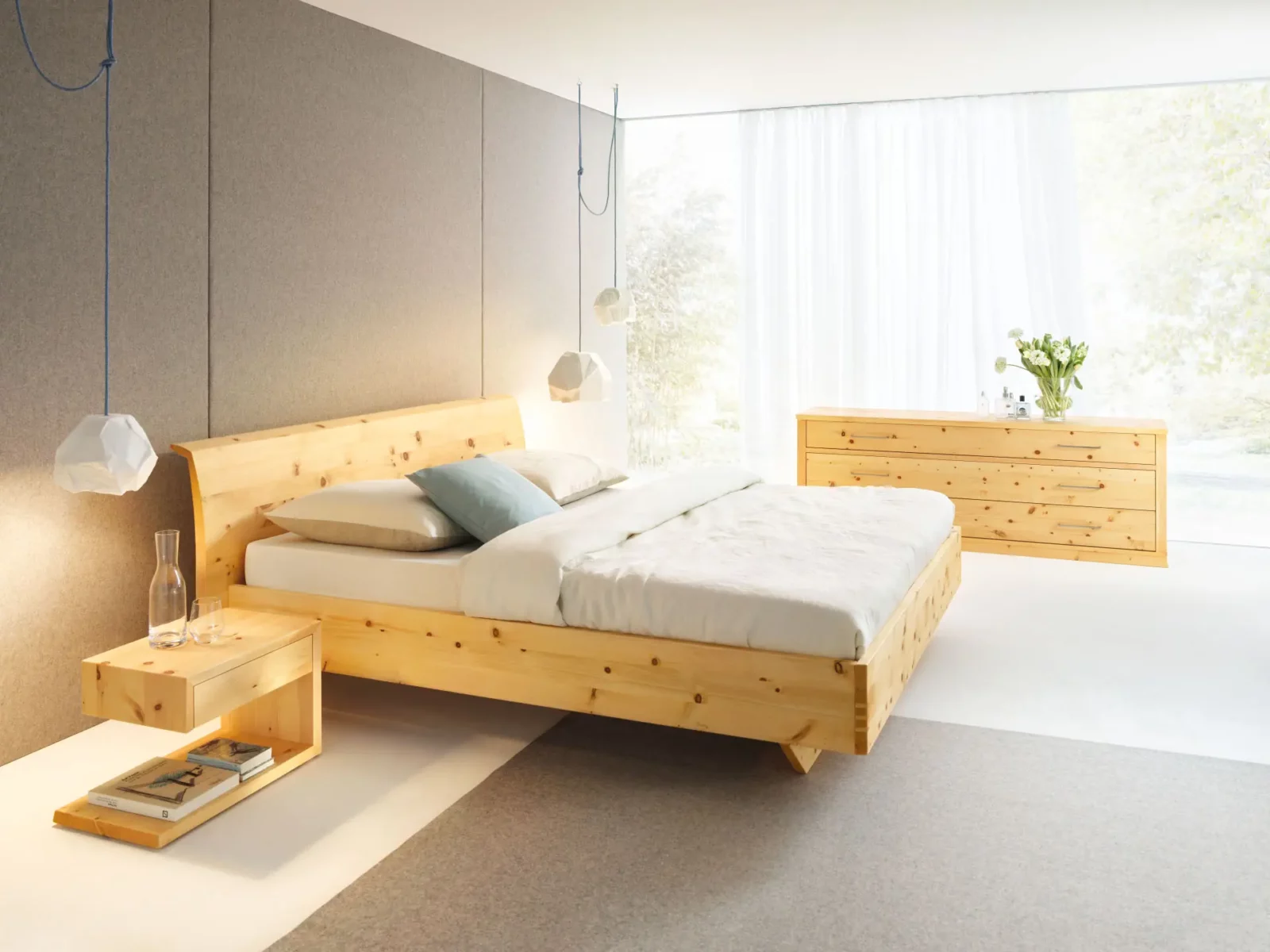 Bett aus Zirbenholz, natur geölt, mit passender Kommode im Hintergrund.