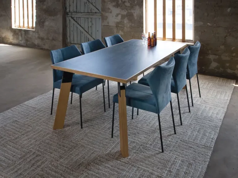 Esstisch mit blauer Tischplatte und blauen Stühlen aus Leder.