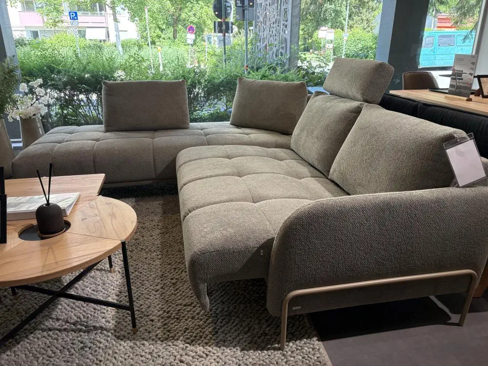 Ecksofa Bounty in grauem Stoff mit verstellbaren Kopfstützen und Metallfüßen.