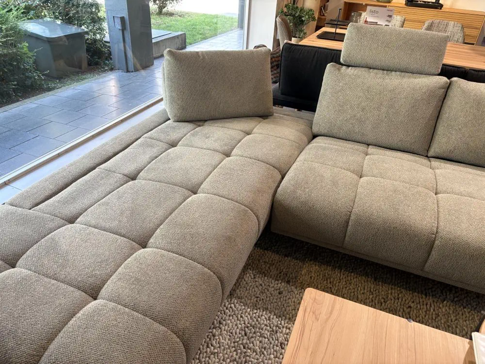 Ecksofa Bounty in beige mit verstellbaren Kopfstützen und gepolsterter Sitzfläche.