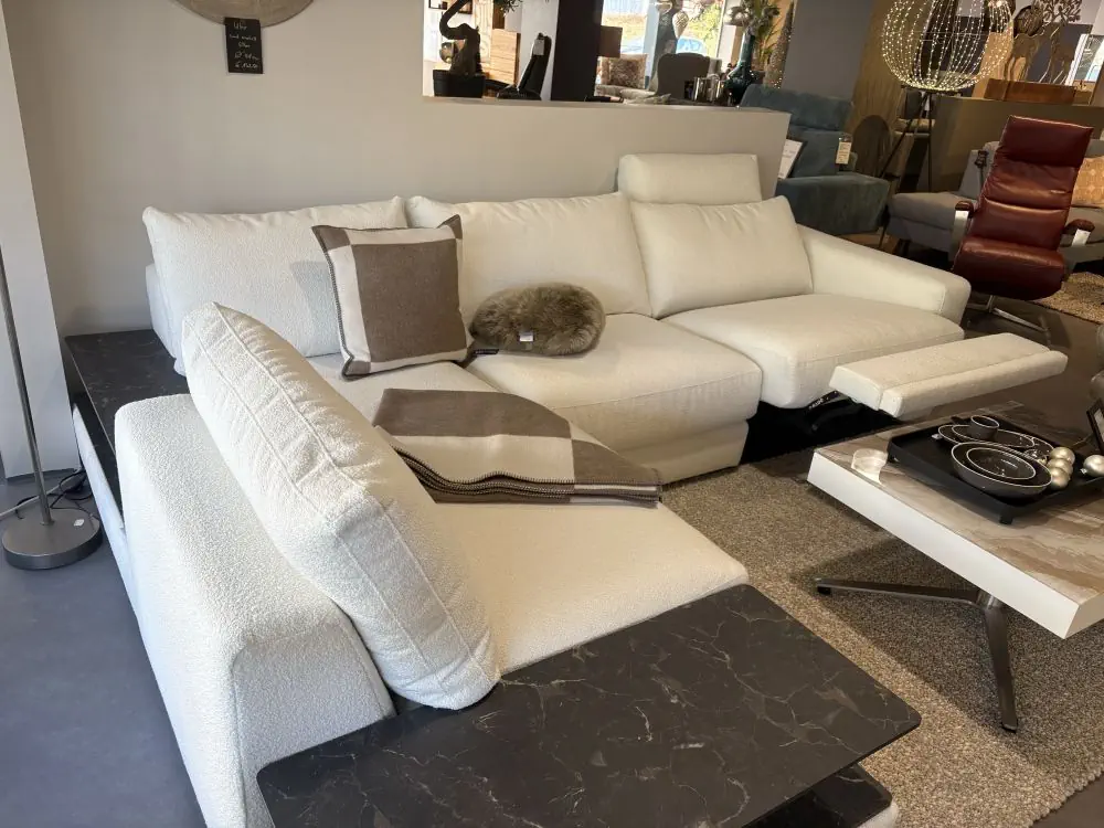 Ecksofa Gina in weißem Stoff mit schwarzen Marmor-Ablagen.
