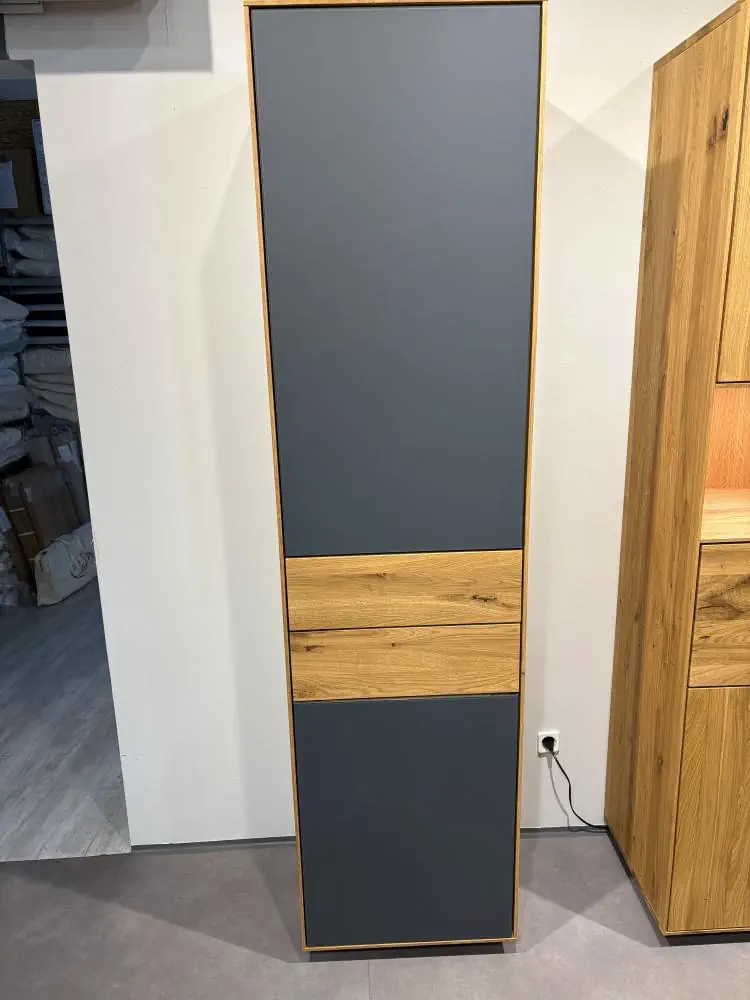 Hochschrank aus Holz mit grauen Fronten und natürlicher Holzmaserung.