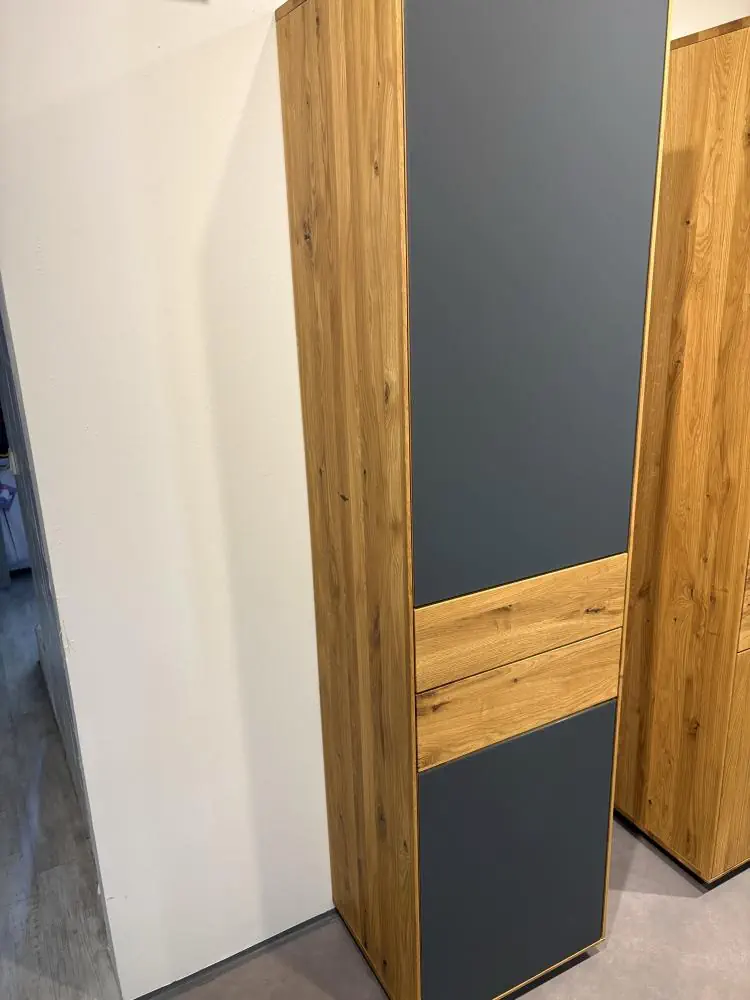 Hochschrank aus Holz mit grauen Fronten und mittlerem Holzstreifen.
