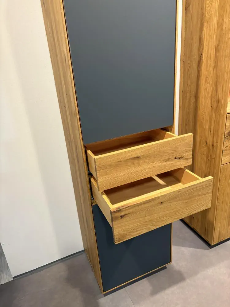 Hochschrank mit Eichenholz und grauen Fronten, zwei offene Schubladen.