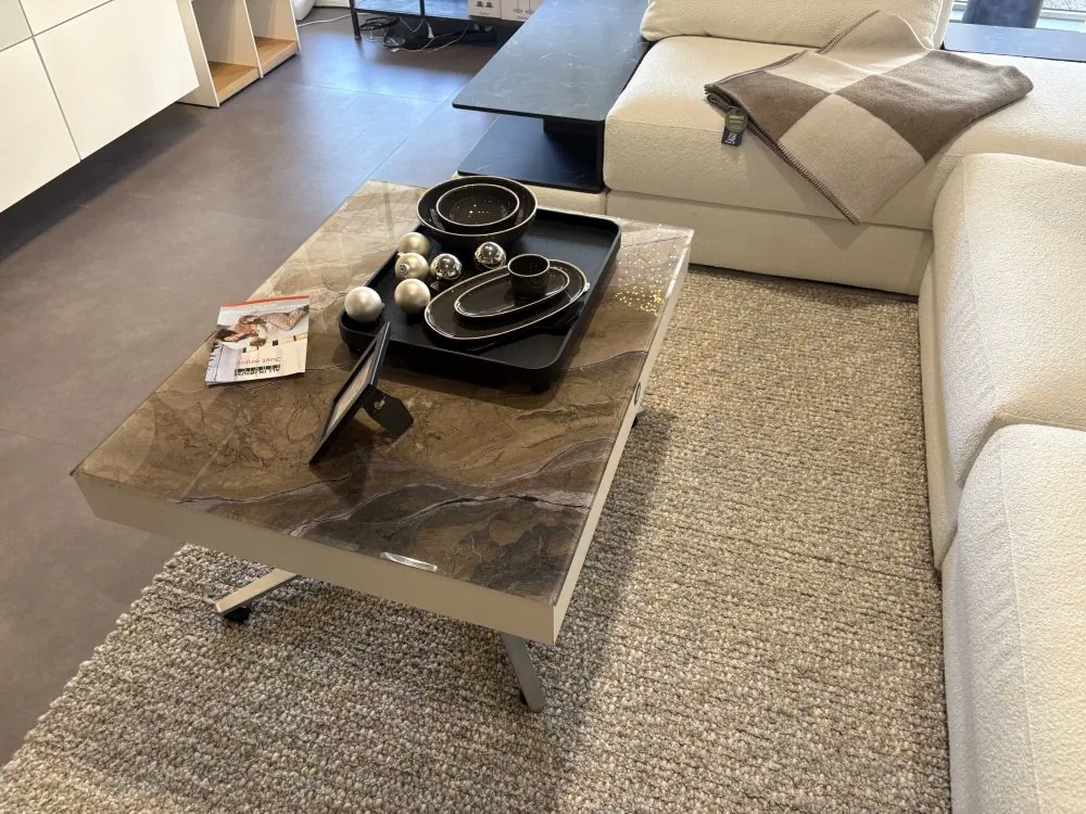 Couchtisch mit marmorierter Glasplatte und Metallgestell in modernem Design.