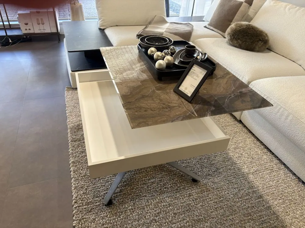 Couchtisch mit Glasplatte mit Steinoptik und Schublade, weißes Gestell, modernes Design.