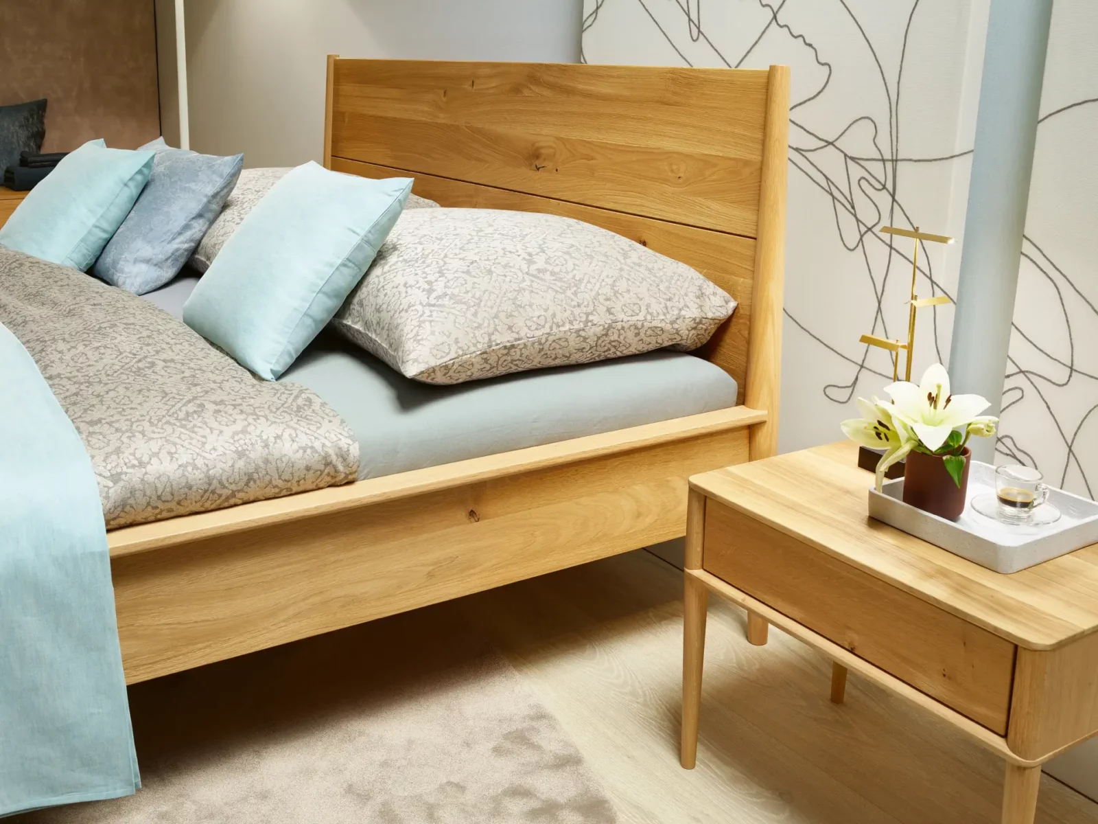 Anrei Juna Bett aus hellem Holz mit passendem Nachttisch.