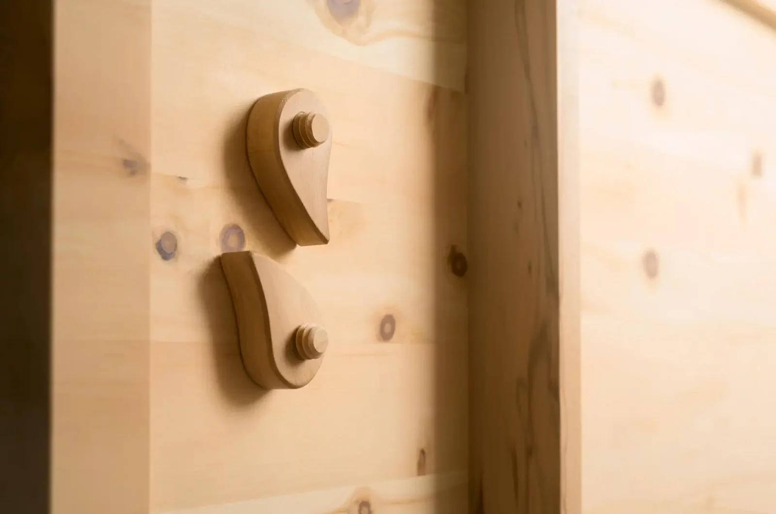 Anrei Paso Schrank aus hellem Holz mit markanten Holzgriffen.