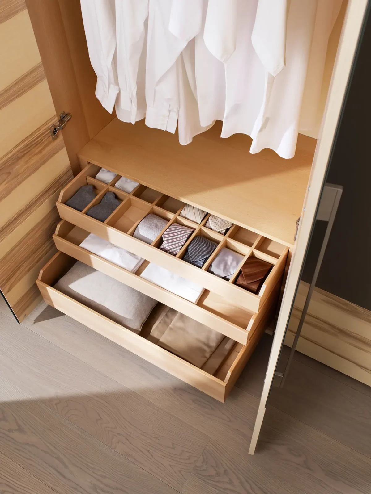 Anrei Tesso Kleiderschrank mit Schubladen und Fächern aus hellem Holz.