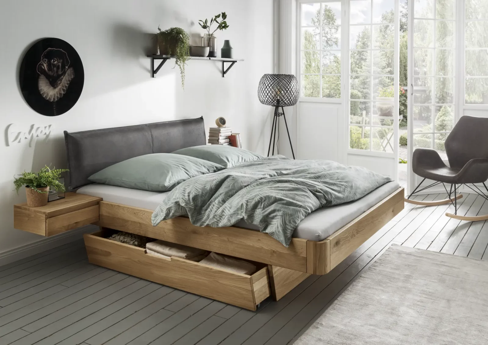Bett Cleve aus Eichenholz mit grauem Polsterkopfteil und Schubladen.