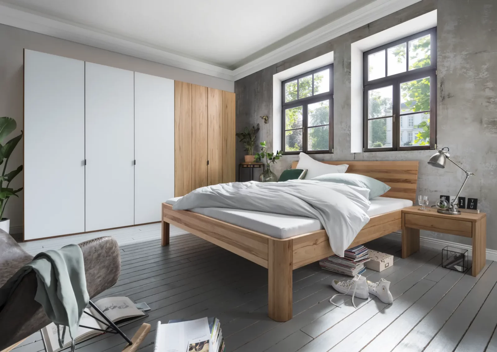 Bett Cleve aus Holz mit schlichtem Design und heller Bettwäsche.