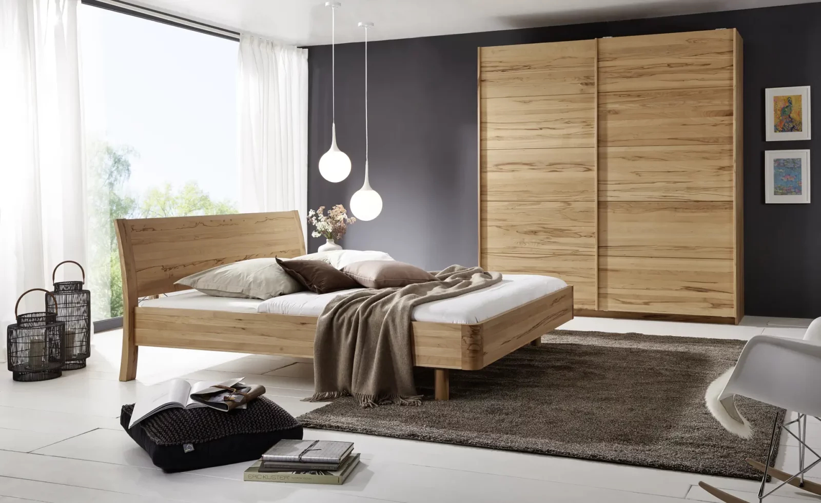 Holzschmiede Bett Swing aus hellem Holz mit geschwungenem Kopfteil.