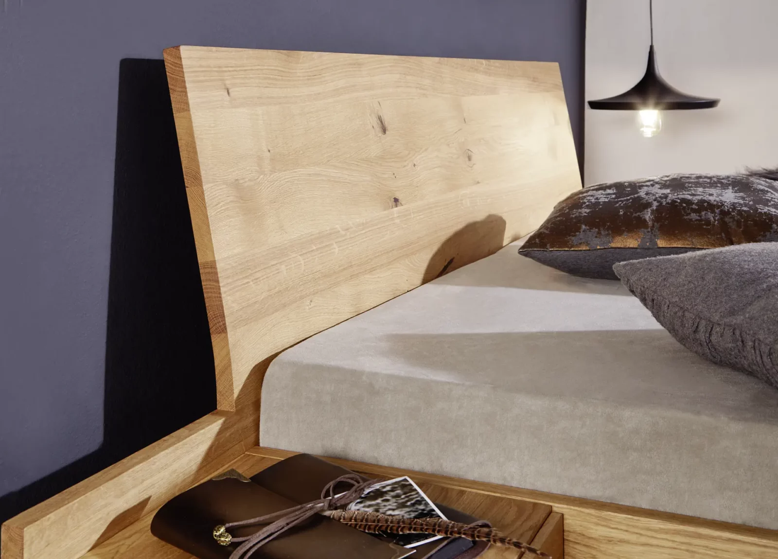 Holzschmiede Bett Tenso in heller Eiche mit schrägem Kopfteil.