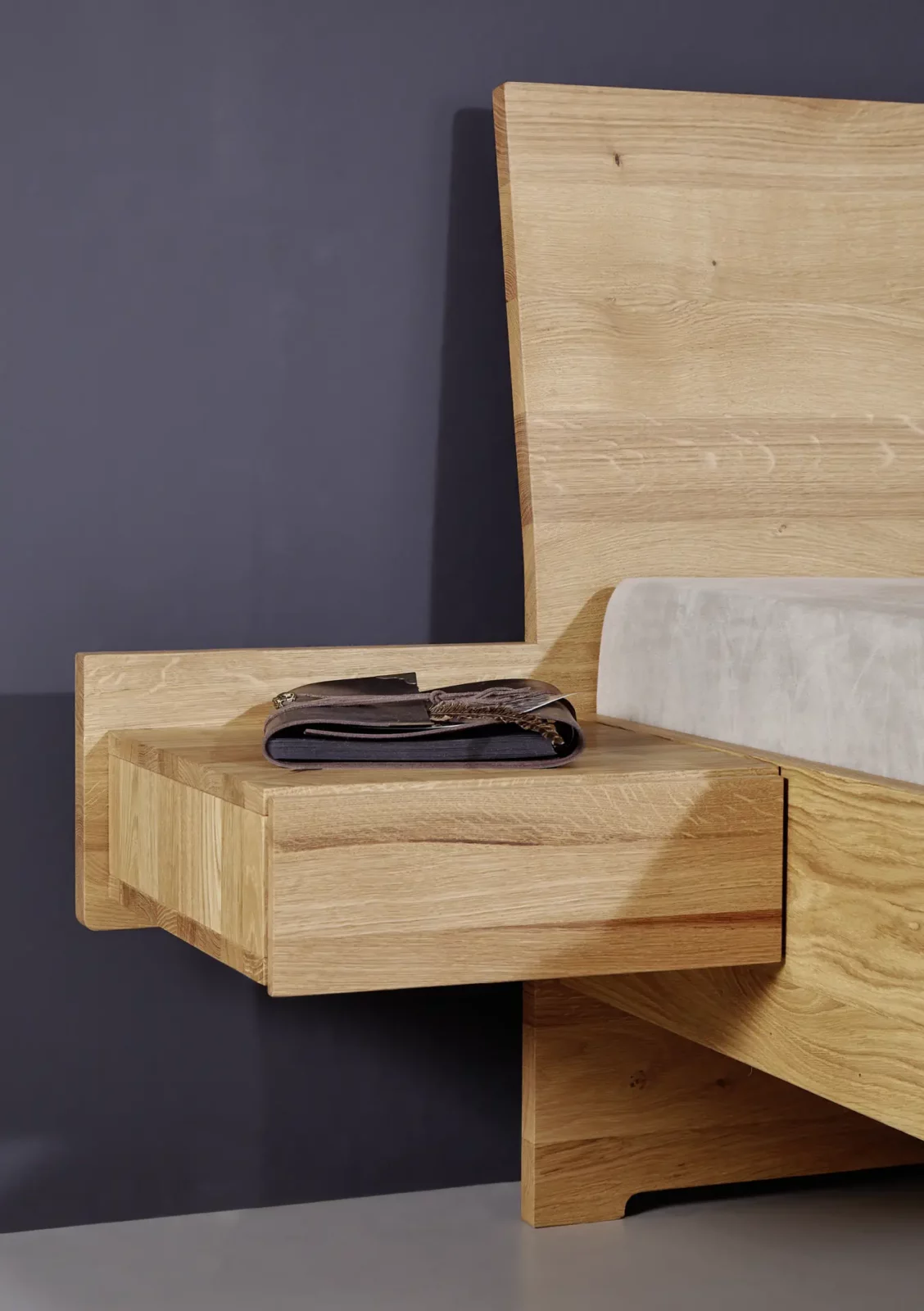 Holzschmiede Bett Tenso aus hellem Holz mit integriertem Nachttisch.
