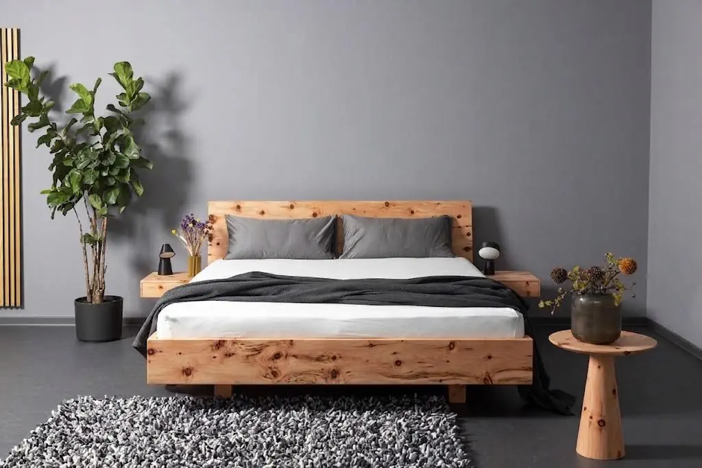 Hüsler Nest Bett Onira aus Zirbenholz mit grauer Bettwäsche.