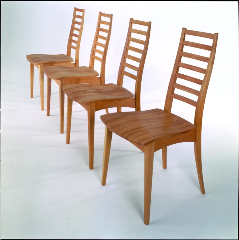 Stuhl Julia aus Holz mit geschwungener Sitzfläche und Sprossenlehne.